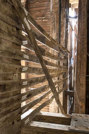 Widely spaced lath on hall side of partition with the passage.