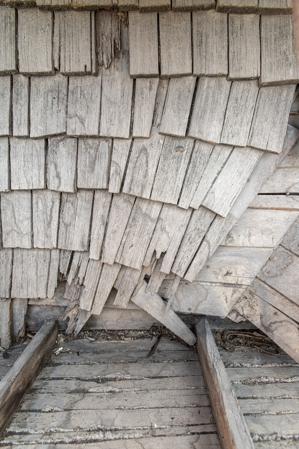Riven clapboard sheathing bent at the valley of the sttair tower