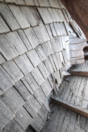 Riven clapboard sheathing bent at the valley of the sttair tower