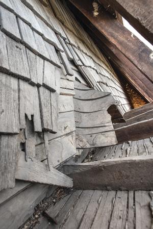 Riven clapboard sheathing bent at the valley of the sttair tower