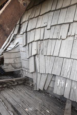 Riven clapboard sheathing bent at the valley of the sttair tower