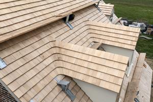 Recreated shingle roof with swept valleys on back building dorme