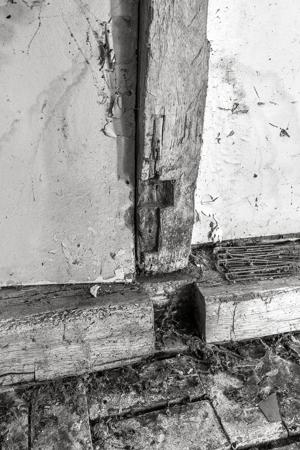 Remnants of wooden hinges for abandoned front doorway