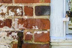 Graffiti carved into rubbed brick of window jamb on front of ori