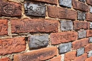 Early graffiti carved into bricks on front