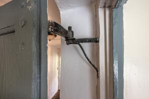 Offset strap hinge on rat's tail pintle; rear door to passage, w