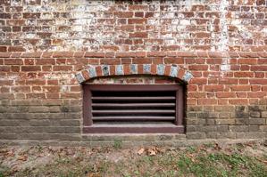 Segmntal arch of cellar window with alternating glazed headers; 
