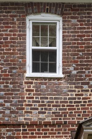 Second-story window with segmental arch and alternating glazed h